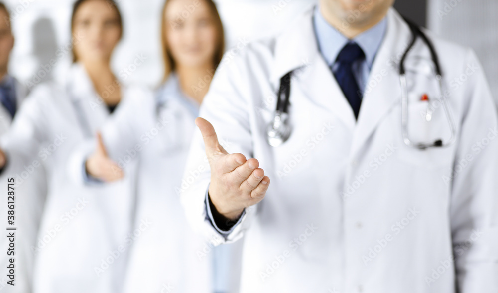 Team of unknown doctors is offering helping hand to the patients, close up. Physicians ready to help people. Medical help, insurance in health care, medicine concept Team of unknown doctors is offering helping hand to the patients, close up. Physicians ready to help people. Medical help, insurance in health care, medicine concept