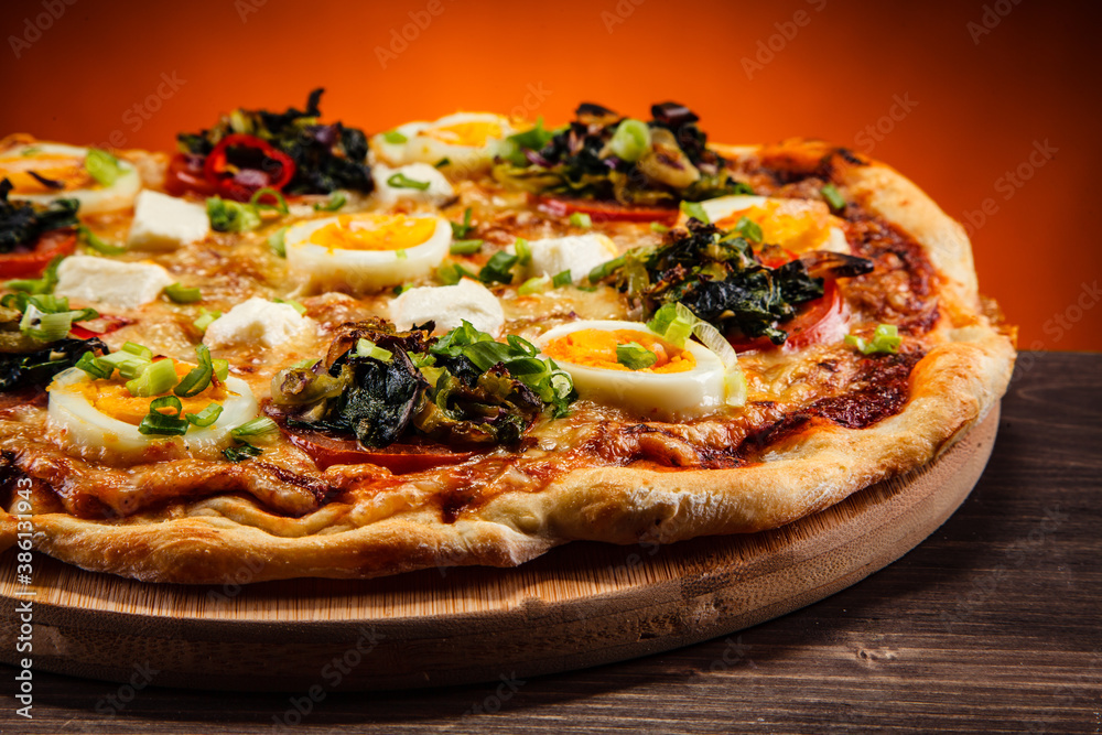 Pizza pepperoni with hard boiled eggs on wooden table
Pizza pepperoni with hard boiled eggs on wooden table