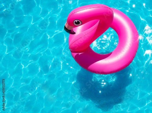 Stampa su tela Inflatable flamingo buoy swim in the swimming pool view from above
