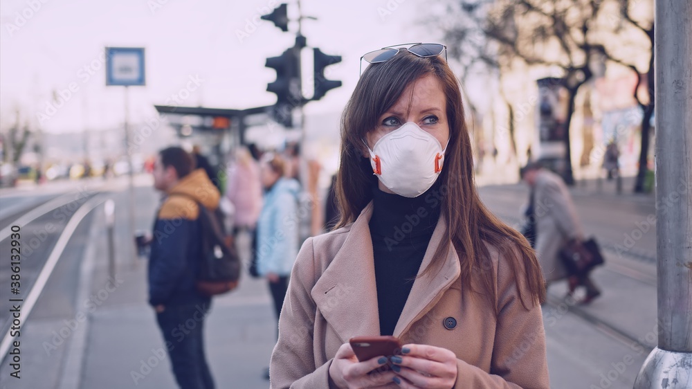 COVID-19 Pandemic - Woman in city street wearing protective face mask on street to stop coronavirus. COVID-19 Pandemic - Woman in city street wearing protective face mask on street to stop coronavirus.
