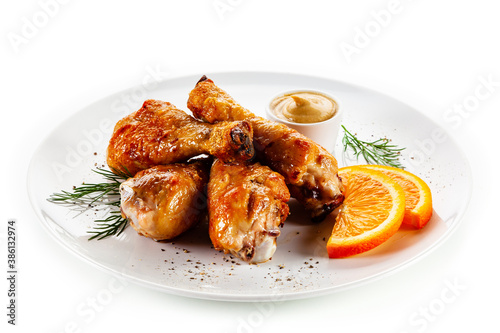 Barbecue chicken drumsticks with vegetables on white background
