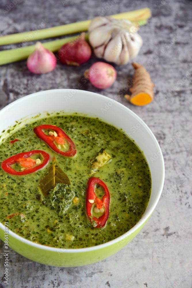 Daun ubi tumbuk or daun singkong or pounded and seasoned cassava leaves. Traditional Indonesian cuisine Daun ubi tumbuk or daun singkong or pounded and seasoned cassava leaves. Traditional Indonesian cuisine
