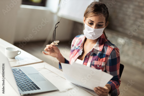  Young businesswoman wears mask while working at casual office