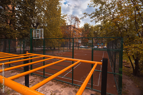 Basketball court in the courtyard in a poor neighborhood, autumn time, copy space