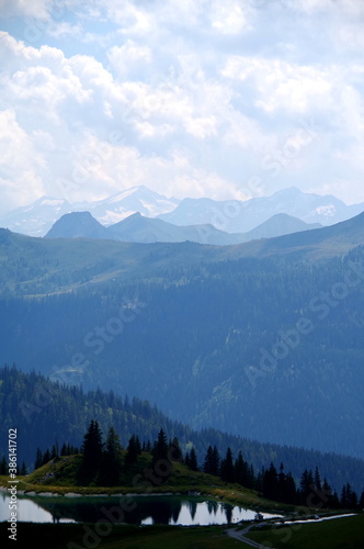 Blick vom Berggipfel in die Alpen mit See im Vordergrund 1