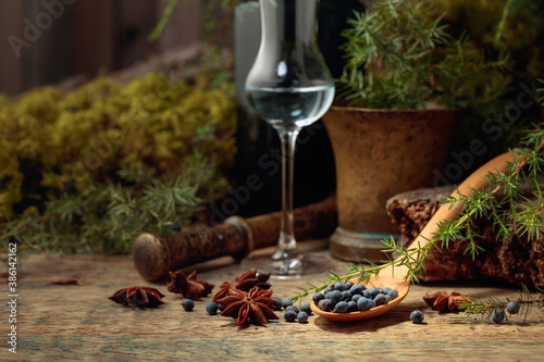 Gin, anise, and juniper berries on a wooden table. photo