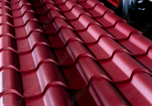 Red metallic roof tiles background with drops of water.