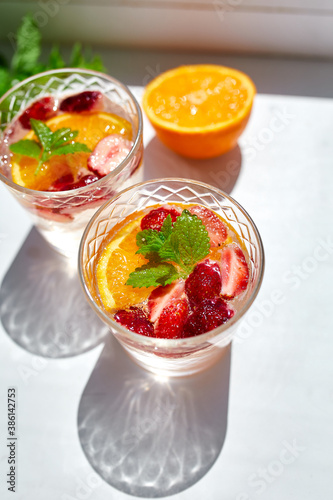 Summer cocktail with strawberry, orange and mint in glass