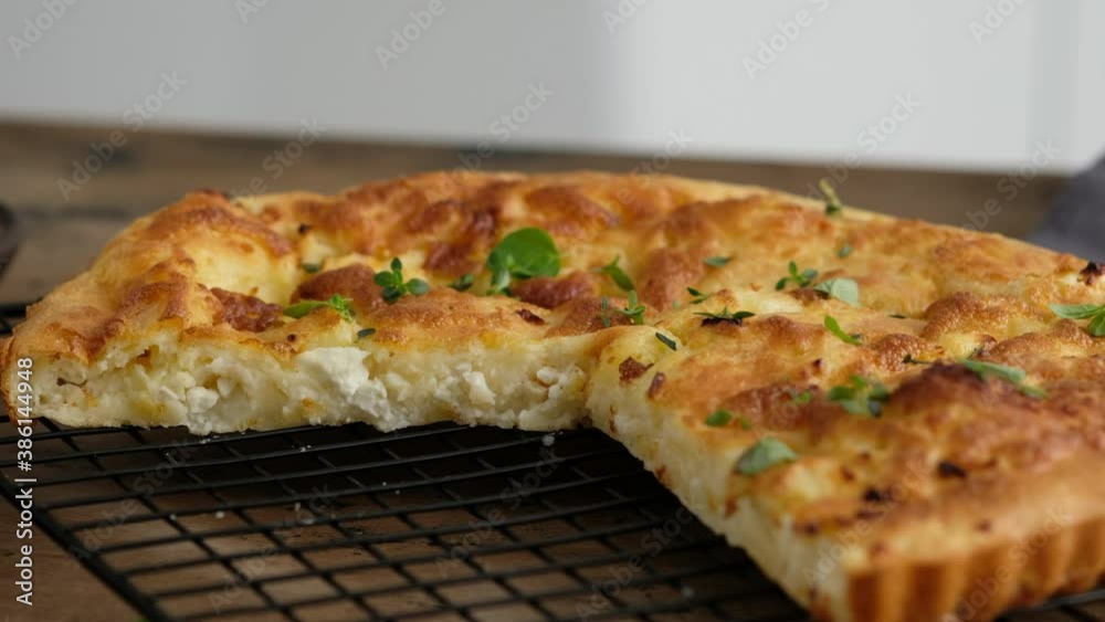 Greek cheese pie. Cuts pie. Slice pie. Woman prepares a pie with feta cheese and microgreens. Black background. Greek cheese pie. Cuts pie. Slice pie. Woman prepares a pie with feta cheese and microgreens. Black background.