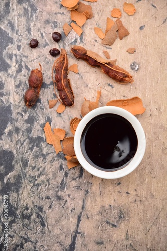 Tamarind paste with fresh ripe tamarind. Flat lay photo