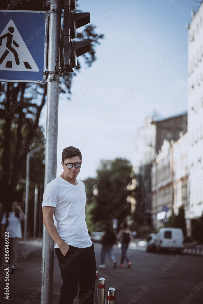 Fototapeta premium Guy stand on the city street, look camera and around