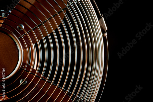 Brass Desk Fan Section Against a Black Background