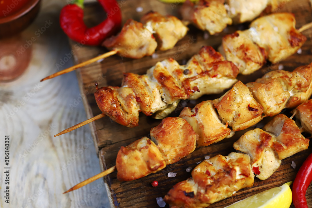 Selective focus. Appetizing chicken skewers on wooden sticks. Rustic style.