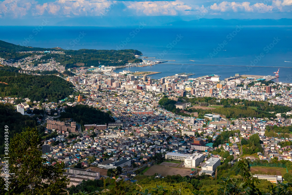 天狗山の山頂から眺めた、小樽市街地の街並みと青空が映える石狩湾