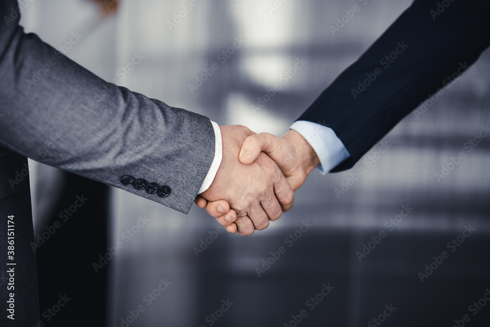 Business people in office suits standing and shaking hands, close-up. Business communication concept. Handshake and marketing Business people in office suits standing and shaking hands, close-up. Business communication concept. Handshake and marketing