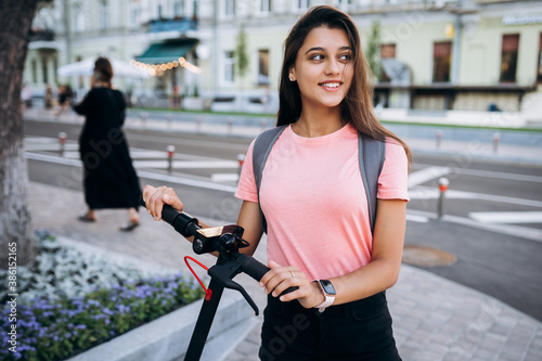 Young beautiful woman riding an electric scooter. © teksomolika