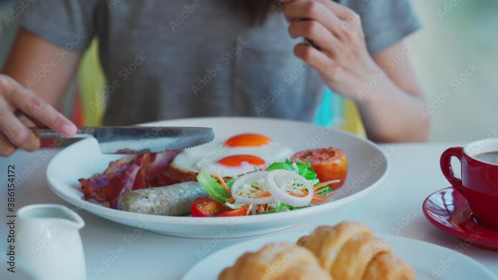 Young woman with cup of coffee eating breakfast Young woman with cup of coffee eating breakfast