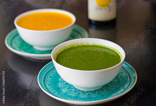 Green and yellow cream soup in the bowl on the restaurants table