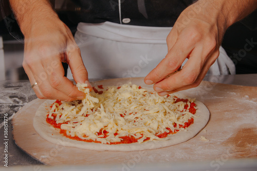 preparing artisan pizza in Italian style pizzeria