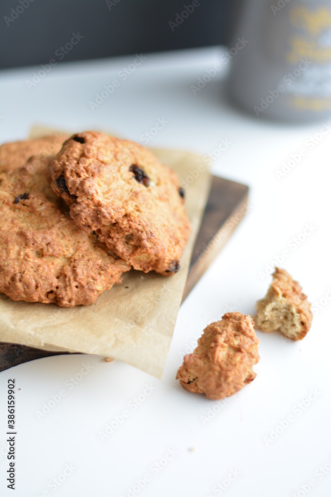 Gray jar with homemade oatmeat cookies on wooden board. Copy space.