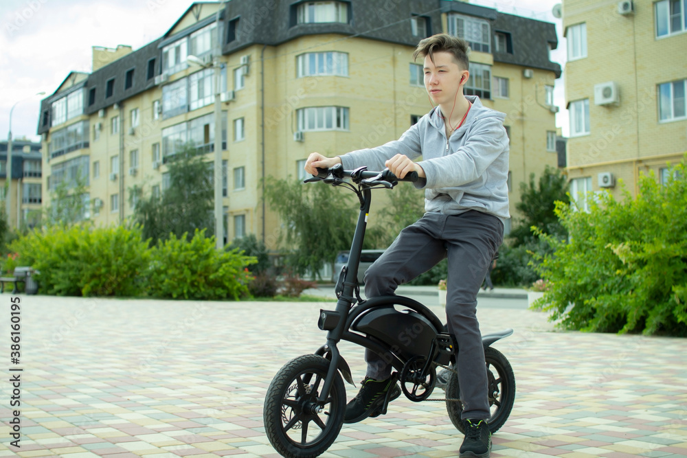 A teenager rides around the city on an electric bike.