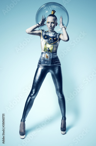 cyborg woman in silver suit with hands inside of helmet © Artem Popov