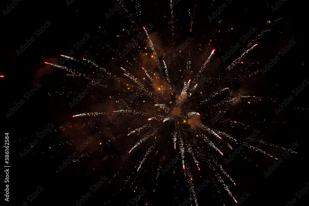 On a black background, golden rays and sparks of scattering fireworks. On a black background, golden rays and sparks of scattering fireworks.