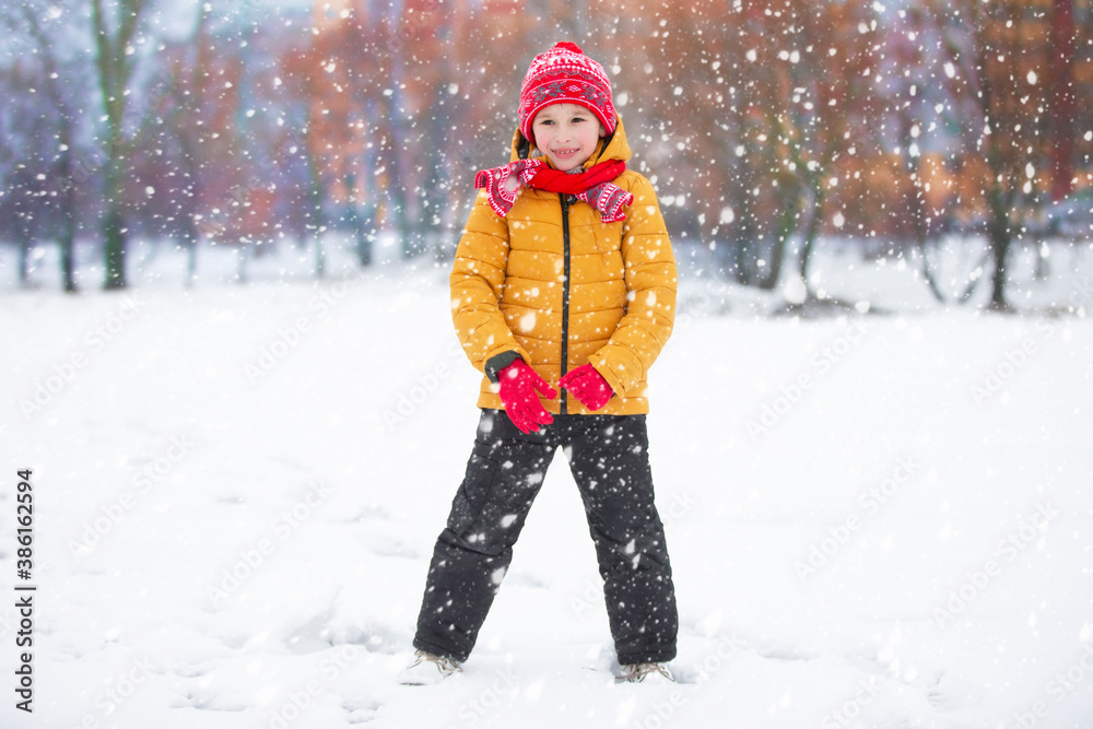 Child in winter. The boy plays on the street against the background of snow. Child in winter. The boy plays on the street against the background of snow.