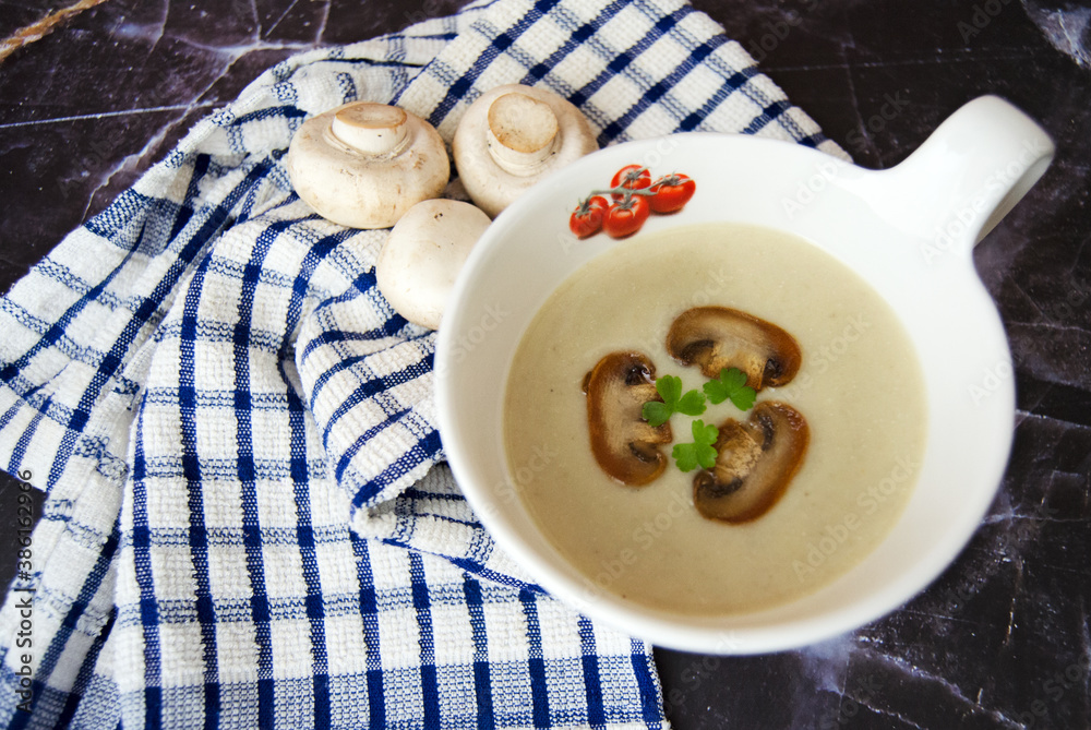 Mushroom cream soup close-up. Champignon soup puree, pie and champignon on a dark granite background. Tasty winter vegetarian food. Mushroom cream soup close-up. Champignon soup puree, pie and champignon on a dark granite background. Tasty winter vegetarian food.