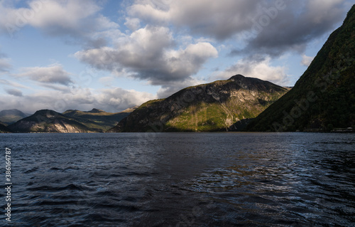 Travelling in the fjord between Linge and Eidsdal in Norway with high mountains on the sides