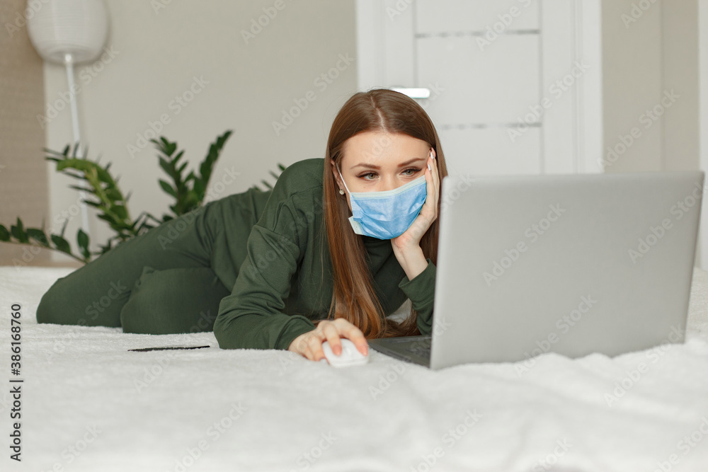 Woman with a laptop. Girl at home. Famale on a bed. Corona virus theme. Woman with a laptop. Girl at home. Famale on a bed. Corona virus theme.