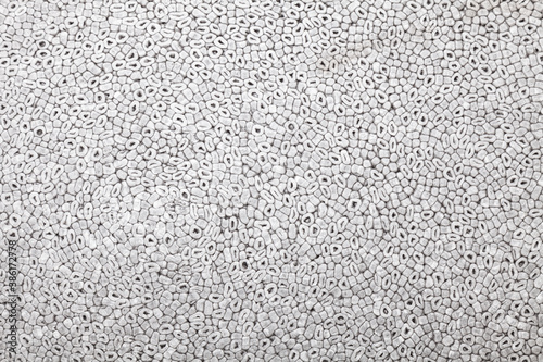 Background and texture of gray soft foam with round chips. Styrofoam.