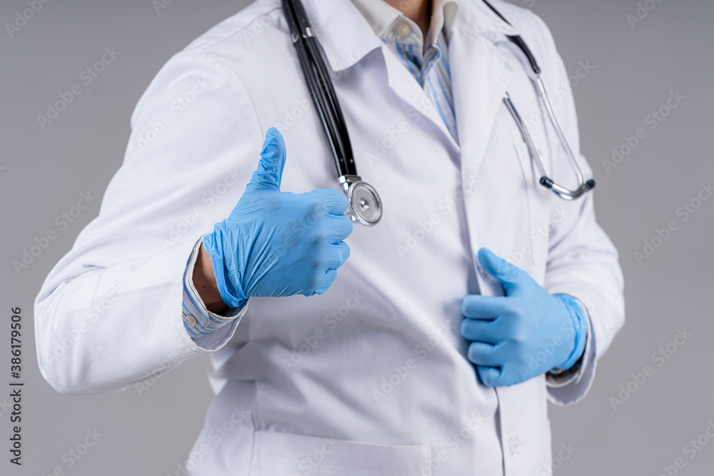 Doctor in scrubs and stethoscope showing like isolated on gray background. Selective focus. Health care concept. Cropped photo. Doctor in scrubs and stethoscope showing like isolated on gray background. Selective focus. Health care concept. Cropped photo.