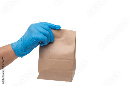 Close up hand in medical glove and holding food paper bag on white background ( Isolated background). Concept of Ordering food online and delivery service. © Prot