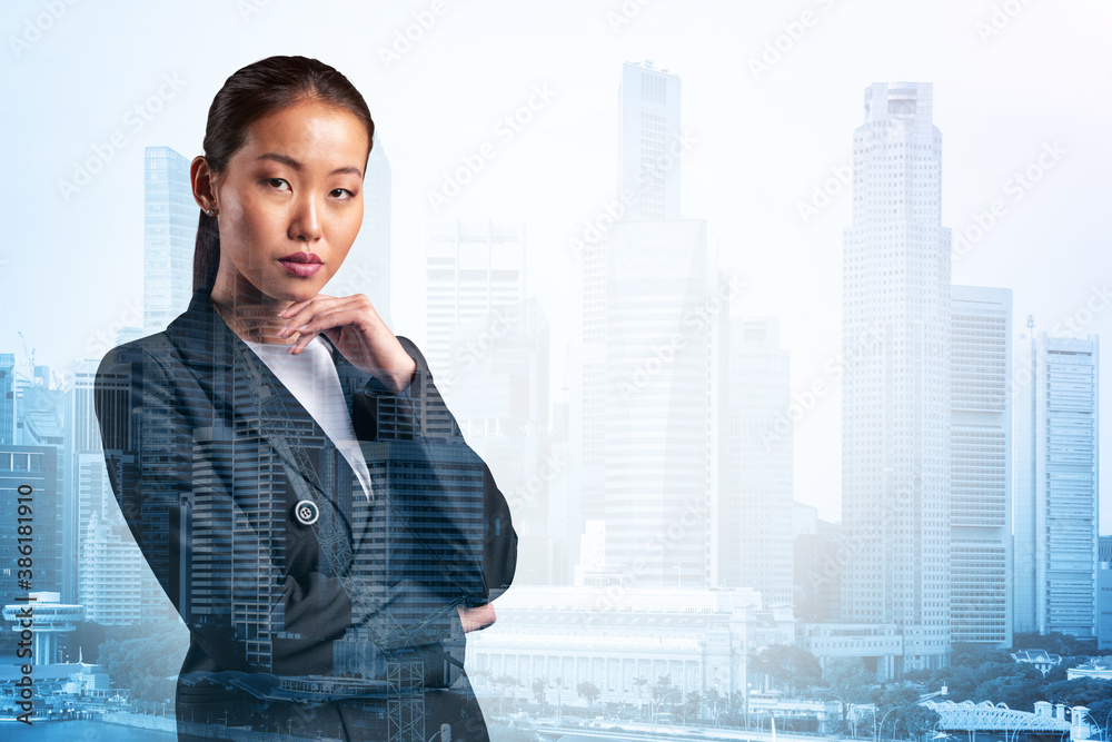 Attractive young Asian business woman in suit with hand on chin thinking how to succeed, new career opportunities, MBA. Singapore on background. Double exposure. Attractive young Asian business woman in suit with hand on chin thinking how to succeed, new career opportunities, MBA. Singapore on background. Double exposure.