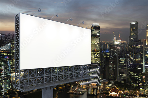 Blank white road billboard with Singapore cityscape background at night time. Street advertising poster, mock up, 3D rendering. Side view. The concept of marketing communication to sell idea.