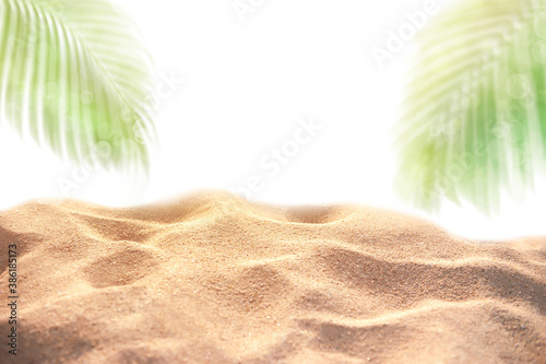 Summer sand dune with empty space for product display and blured coconut palm leaves as frame is on white background Montage of summer relaxation background