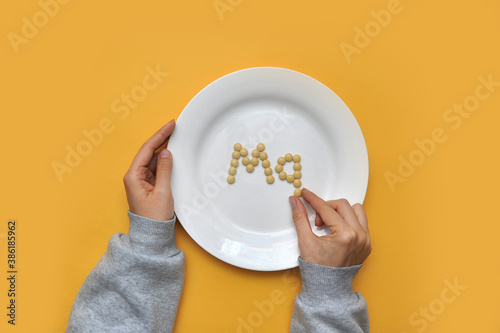 Foto Sign of the trace element magnesium from tablets on a white plate