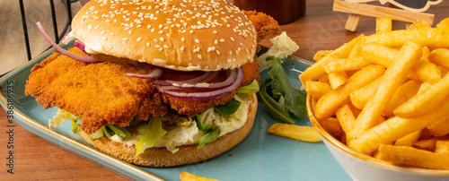 Crispy Chicken Burger mit Hähnchenbrustfilet, Mayonnaise, Tomate, Salat, Zwiebeln dazu Pommes frites