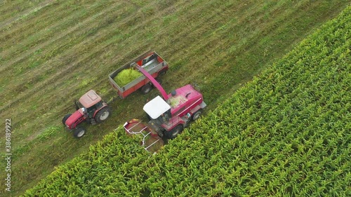 High Angle follow combine harvester removes crop from green field into tractor, Moscow area, Russia