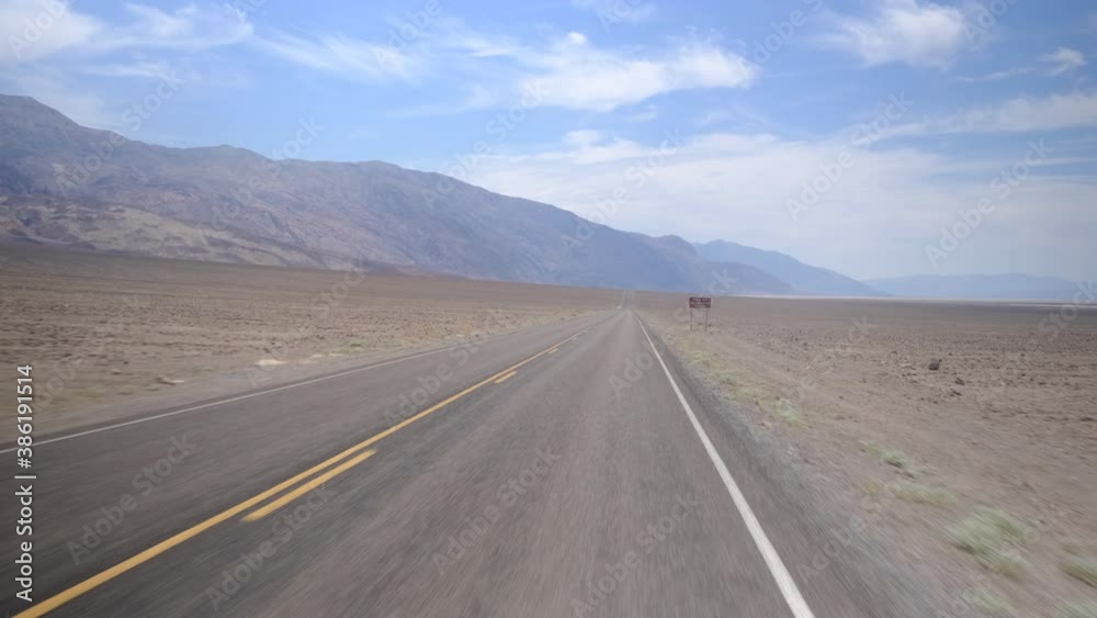 Movement on an empty road going into the distance to red mountain rocks in the canyon landscape in the dry desert. The road with the black asphalt and the orange markings. Slow motion, sunny day
Movement on an empty road going into the distance to red mountain rocks in the canyon landscape in the dry desert. The road with the black asphalt and the orange markings. Slow motion, sunny day