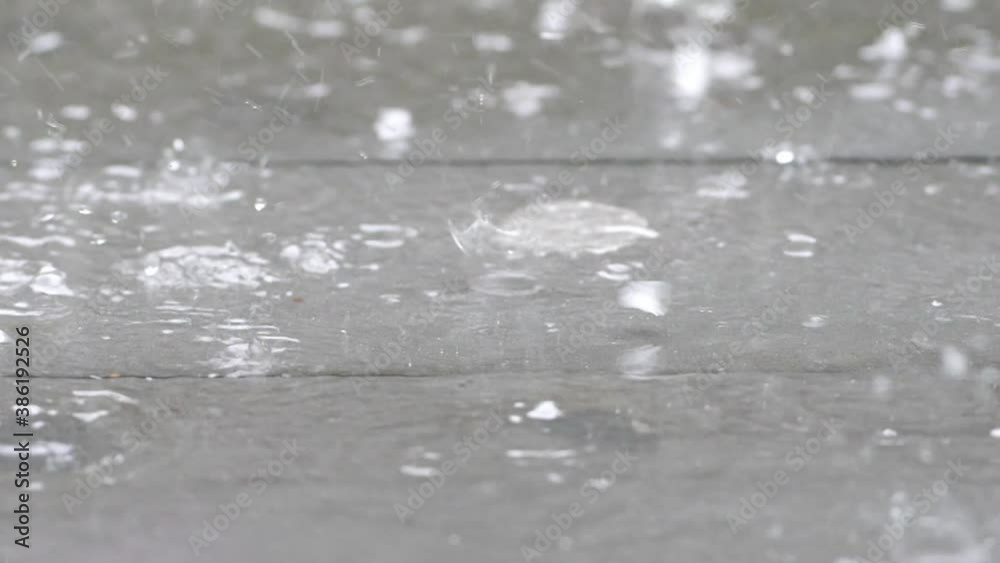 Slow motion speed close up scene on raindrop with hailstone fall against and bounce on floor, flood in bad rainy day, natural pattern of pouring rain and hail bump on ground, grainy texture of water Slow motion speed close up scene on raindrop with hailstone fall against and bounce on floor, flood in bad rainy day, natural pattern of pouring rain and hail bump on ground, grainy texture of water