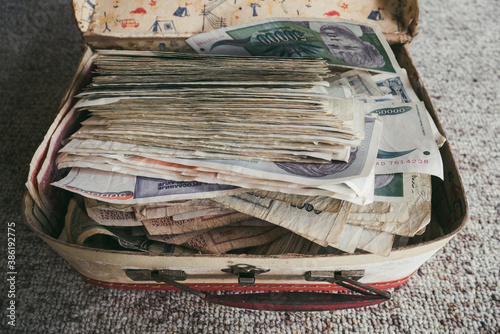 A top view of a pile of worthless money from the time of hyperinflation in Yugoslavia. A children's suitcase full of worthless money. The concept of inflation and hyperinflation photo