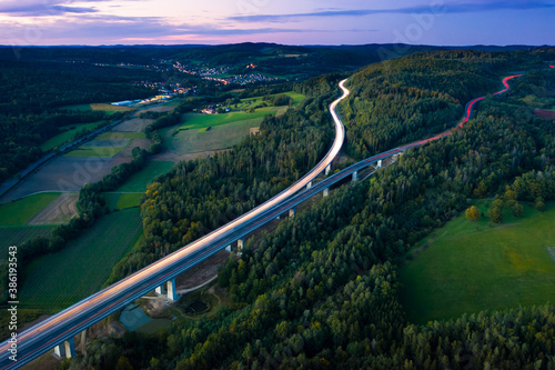 Aerial long exposure view of highway around forest hill