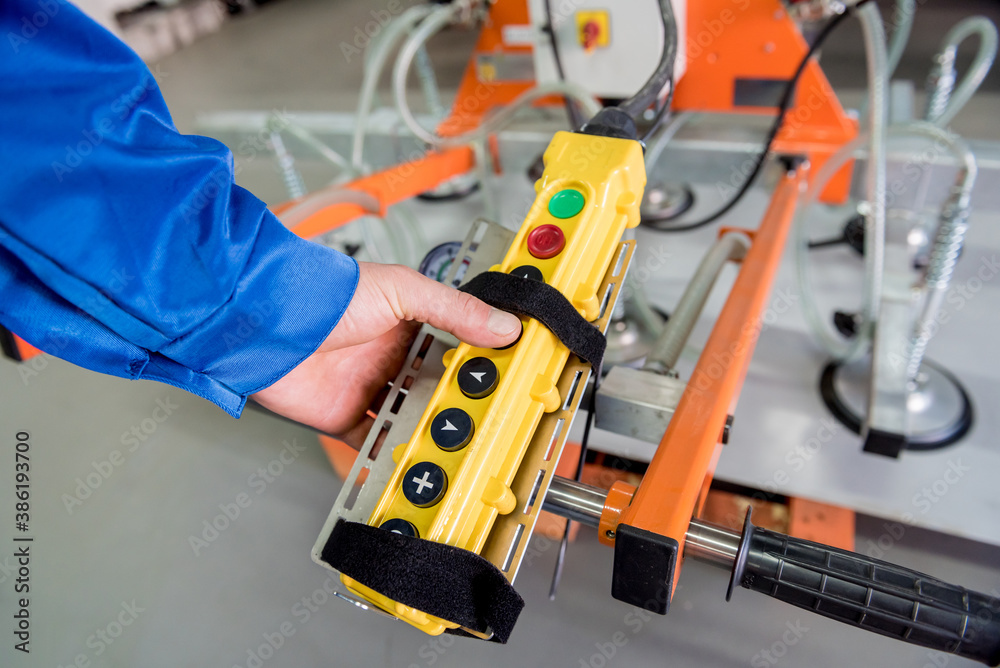 Worker uses suction cups for transporting large sheets of metal