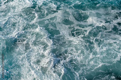 Mar revuelto, visto desde arriba, en colores turquesas y blancos.