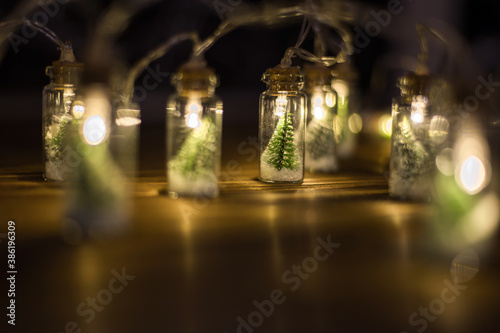 Low key Image of christmas tree in mason jar with garland warm lights photo