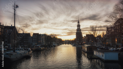 View on the canal Oudeschans at Sunset with the tower Montelbaanstoren in the background in Amsterdam.