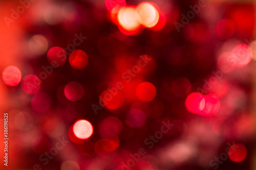 Red blurry bokeh and highlights. Disco lights. Bokeh glows on a dark background. Christmas garlands with a blurred focus in the form of a red bokeh. © Елена Труфанова