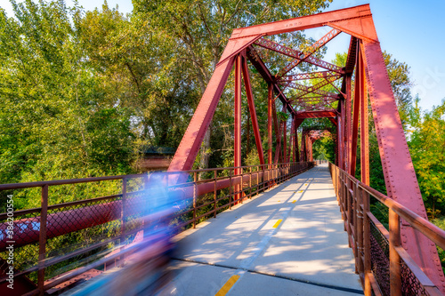 Bike rider motion blur crossing a bridge over the Boise River